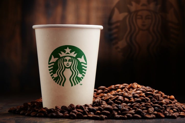 Composição com xícara de café Starbucks e grãos Composição com xícara de café Starbucks e grãos